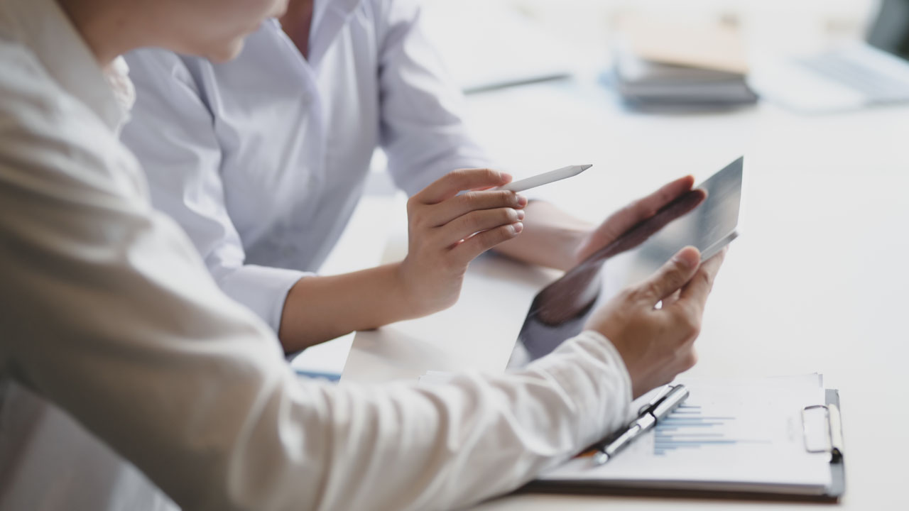 Two people looking at a tablet